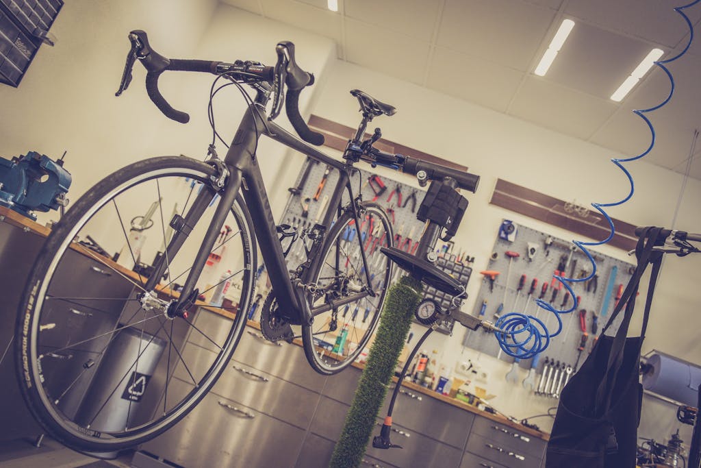 Detailed view of a bicycle being repaired in a modern workshop with tools and equipment. Representing refurbished bicycles